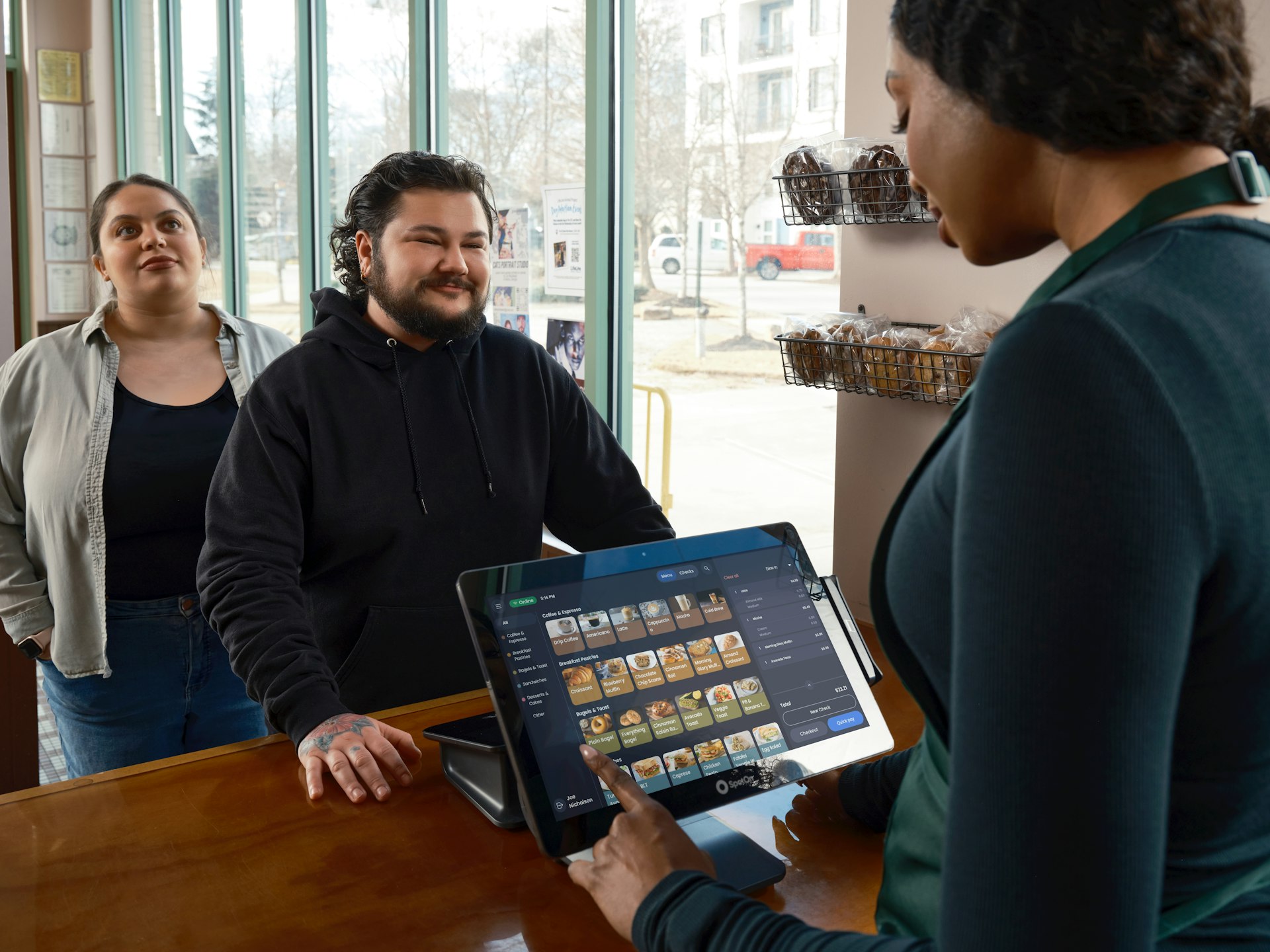 Customers ordering at a counter with a tablet